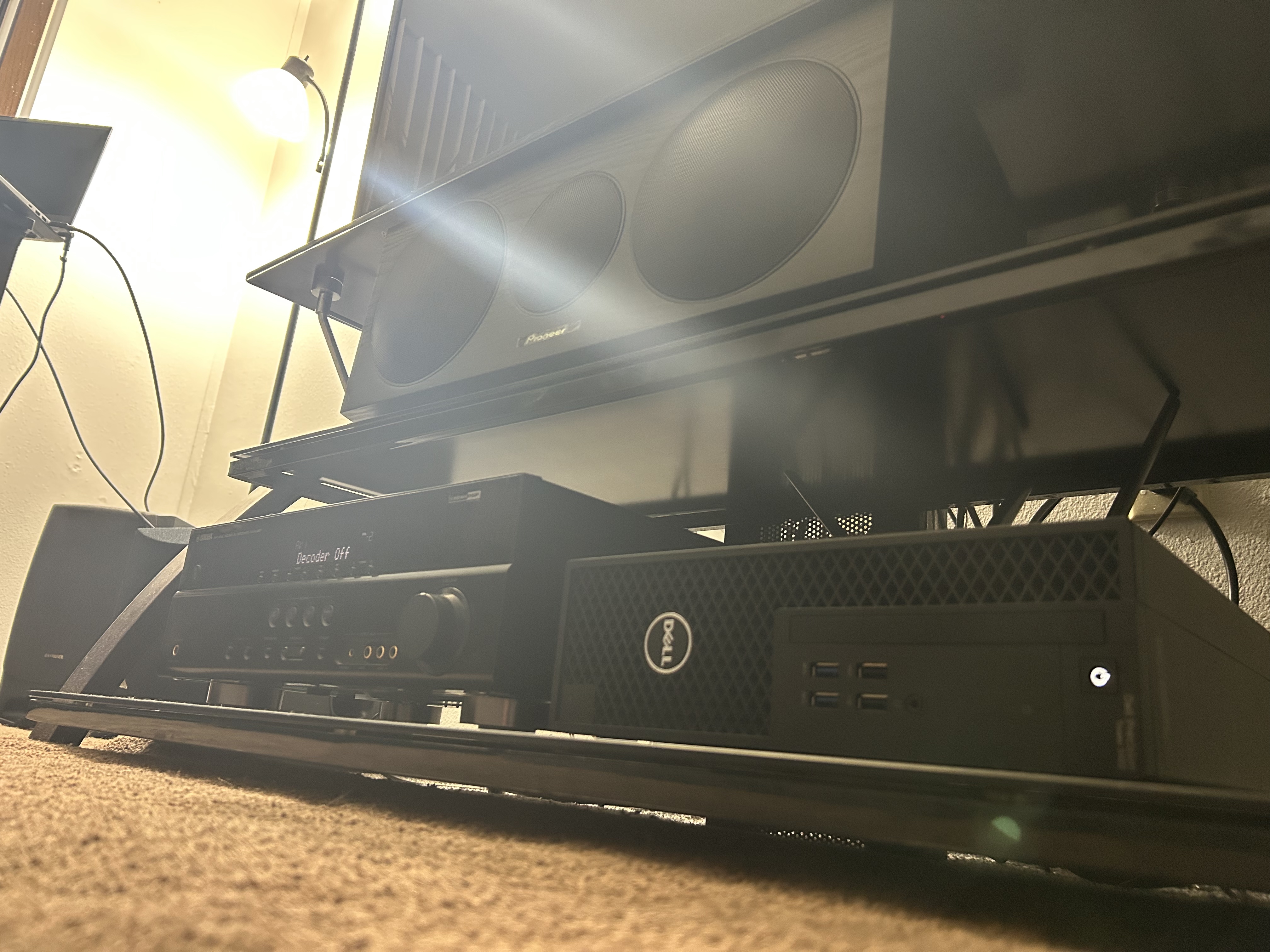 Picture of a Dell Precision Tower 3420 SFF sitting sexily on the bottom rack of a tempered glass TV stand.